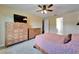 Bright bedroom with soft carpet, ceiling fan, view of an ensuite bathroom, and storage drawers at 11911 Sunburst Marble Rd, Riverview, FL 33579
