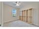 Bright bedroom features neutral tones, a ceiling fan, large window, and built-in display shelving at 11911 Sunburst Marble Rd, Riverview, FL 33579
