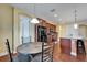 Open dining area with tile table, wood floors, black appliances, and view of the kitchen island at 11911 Sunburst Marble Rd, Riverview, FL 33579