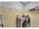 Laundry room featuring a newer washer and dryer, shelving, and yellow paint at 11911 Sunburst Marble Rd, Riverview, FL 33579