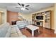 Cozy living room featuring a fireplace, wood floors, and comfortable seating at 11911 Sunburst Marble Rd, Riverview, FL 33579
