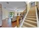 Open-concept living room with wood floors, staircase, and view of screened-in patio at 11911 Sunburst Marble Rd, Riverview, FL 33579