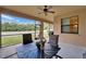 This screened patio offers a peaceful view of the green backyard and a cozy spot for dining at 11911 Sunburst Marble Rd, Riverview, FL 33579