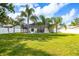 Backyard view of the screened-in lanai, pool, and well-maintained green lawn at 12106 Clearbrook Ct, Riverview, FL 33569