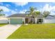 Charming single-story home with a well-manicured lawn and a lush palm tree in the front yard at 12106 Clearbrook Ct, Riverview, FL 33569