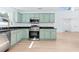 Beautiful kitchen with stainless appliances, green cabinets, a view to the living area and great natural light at 12106 Clearbrook Ct, Riverview, FL 33569