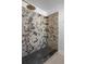 Modern shower showcasing decorative granite walls, sleek hexagon flooring, and rain shower head at 12106 Clearbrook Ct, Riverview, FL 33569