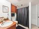 Bathroom with wood cabinets, dark shower curtain, black towels, and decor at 12912 Arbor Isle Dr # 202, Temple Terrace, FL 33637