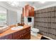 Bathroom with wood cabinets, triangle shower curtain, black towels, and decor at 12912 Arbor Isle Dr # 202, Temple Terrace, FL 33637