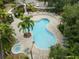 Community pool with sun loungers and tables surrounded by mature trees and well-manicured landscaping at 12912 Arbor Isle Dr # 202, Temple Terrace, FL 33637