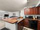 This kitchen features wood cabinets, granite countertops, and black appliances that compliment the decor at 12912 Arbor Isle Dr # 202, Temple Terrace, FL 33637