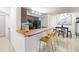 Modern kitchen featuring a breakfast bar with seating, stylish lighting, and essential appliances at 12912 Arbor Isle Dr # 202, Temple Terrace, FL 33637