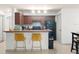 This renovated kitchen features wood cabinets, granite counters, a breakfast bar, and black appliances at 12912 Arbor Isle Dr # 202, Temple Terrace, FL 33637