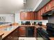This renovated kitchen features wood cabinets, granite counters, and black appliances at 12912 Arbor Isle Dr # 202, Temple Terrace, FL 33637