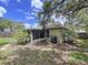 The backyard shows mature trees and partial view of the screened in porch at 1319 Dew Bloom Rd, Valrico, FL 33594