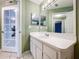 Bathroom with long vanity, white cabinets, and an open door to another room at 1319 Dew Bloom Rd, Valrico, FL 33594