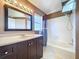 Bathroom with dark wood vanity, tub and shower with tile surround, and good natural light at 1319 Dew Bloom Rd, Valrico, FL 33594