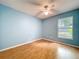Light blue bedroom with wood floors, a ceiling fan, and a large window at 1319 Dew Bloom Rd, Valrico, FL 33594