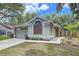 Charming single-story home features an attached garage and beautifully landscaped front yard with mature trees at 1319 Dew Bloom Rd, Valrico, FL 33594