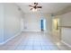 Bright living room features tile flooring, ceiling fan, and neutral walls, flowing into adjacent areas at 1319 Dew Bloom Rd, Valrico, FL 33594