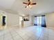 Open-concept living room with tile flooring, ceiling fan, and views of the kitchen and dining area at 1319 Dew Bloom Rd, Valrico, FL 33594