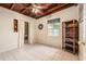 Bedroom with wood ceiling, tile floor, closet, window, wreath, and open dark wood bookcase at 1533 Suffolk N St, St Petersburg, FL 33710