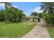 Inviting single-story home featuring lush greenery and a long driveway leading to a detached garage at 1533 Suffolk N St, St Petersburg, FL 33710