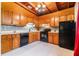 Charming kitchen featuring wood cabinets, black appliances, and tile backsplash at 1533 Suffolk N St, St Petersburg, FL 33710