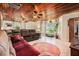 Spacious living room featuring a wooden ceiling, tile flooring, and a comfortable oversized sectional sofa at 1533 Suffolk N St, St Petersburg, FL 33710