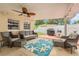 Covered patio features a ceiling fan, outdoor furniture, and a starfish patterned rug at 1533 Suffolk N St, St Petersburg, FL 33710