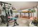 Covered patio with gym equipment, seating, white privacy fence, and brick-paved gazebo area at 1533 Suffolk N St, St Petersburg, FL 33710