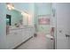 Bright bathroom features a double vanity, a bathtub, and a beautiful beach-themed painting at 2019 Gardenia Landings Lane Ln, Sun City Center, FL 33573