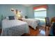 Comfortable bedroom features two twin beds, wood flooring, and a bright window at 2019 Gardenia Landings Lane Ln, Sun City Center, FL 33573