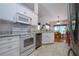 Updated kitchen features white cabinets, modern appliances, marble backsplash, and an open floor plan at 2019 Gardenia Landings Lane Ln, Sun City Center, FL 33573