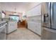 This bright kitchen features white cabinets, modern appliances, and an open layout to the dining area at 2019 Gardenia Landings Lane Ln, Sun City Center, FL 33573