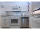 Bright kitchen features white appliances, cabinets, marble backsplash and countertops, and stainless steel dishwasher at 2019 Gardenia Landings Lane Ln, Sun City Center, FL 33573