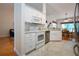 This bright kitchen features white cabinets and appliances, countertops, and open layout to the dining area at 2019 Gardenia Landings Lane Ln, Sun City Center, FL 33573