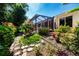 Charming landscaped yard featuring a variety of plants, trees, and a screened lanai at 2019 Gardenia Landings Lane Ln, Sun City Center, FL 33573