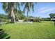 A sprawling backyard with a private pool, mature palm trees, and a fenced in yard at 22422 Stillwood Dr, Land O Lakes, FL 34639