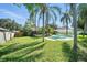 Spacious backyard featuring a well-maintained lawn, mature trees, and a serene swimming pool at 22422 Stillwood Dr, Land O Lakes, FL 34639