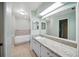 Bright bathroom with double vanity, granite countertops, a bathtub, and modern fixtures at 22422 Stillwood Dr, Land O Lakes, FL 34639
