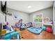 A tidy bedroom featuring playful decor, a window for natural light, and wood flooring at 22422 Stillwood Dr, Land O Lakes, FL 34639