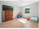 Clean bedroom with laminate wood flooring, a large window, and a vintage dresser at 22422 Stillwood Dr, Land O Lakes, FL 34639
