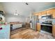 Open kitchen area with stainless steel appliances, wood cabinets, and ample room for dining at 22422 Stillwood Dr, Land O Lakes, FL 34639