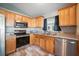 Well-appointed kitchen featuring stainless steel appliances, granite countertops, and warm wood cabinetry at 22422 Stillwood Dr, Land O Lakes, FL 34639