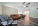 Open concept living room with wood flooring, ceiling fan, neutral colored walls and comfortable furniture at 22422 Stillwood Dr, Land O Lakes, FL 34639