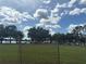 Community park with a lake view, picnic tables, and a playground beyond a chain-link fence at 22422 Stillwood Dr, Land O Lakes, FL 34639