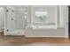 Bright bathroom with white tiling, glass enclosed shower and garden tub with views of backyard at 2812 Windcrest Oaks Ct, Valrico, FL 33594