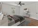A modern bedroom with a view, neutral decor, and wood floors at 2812 Windcrest Oaks Ct, Valrico, FL 33594