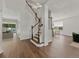 Welcoming foyer showcases hardwood floors, a staircase with wood and white railings, and open-concept living spaces at 2812 Windcrest Oaks Ct, Valrico, FL 33594